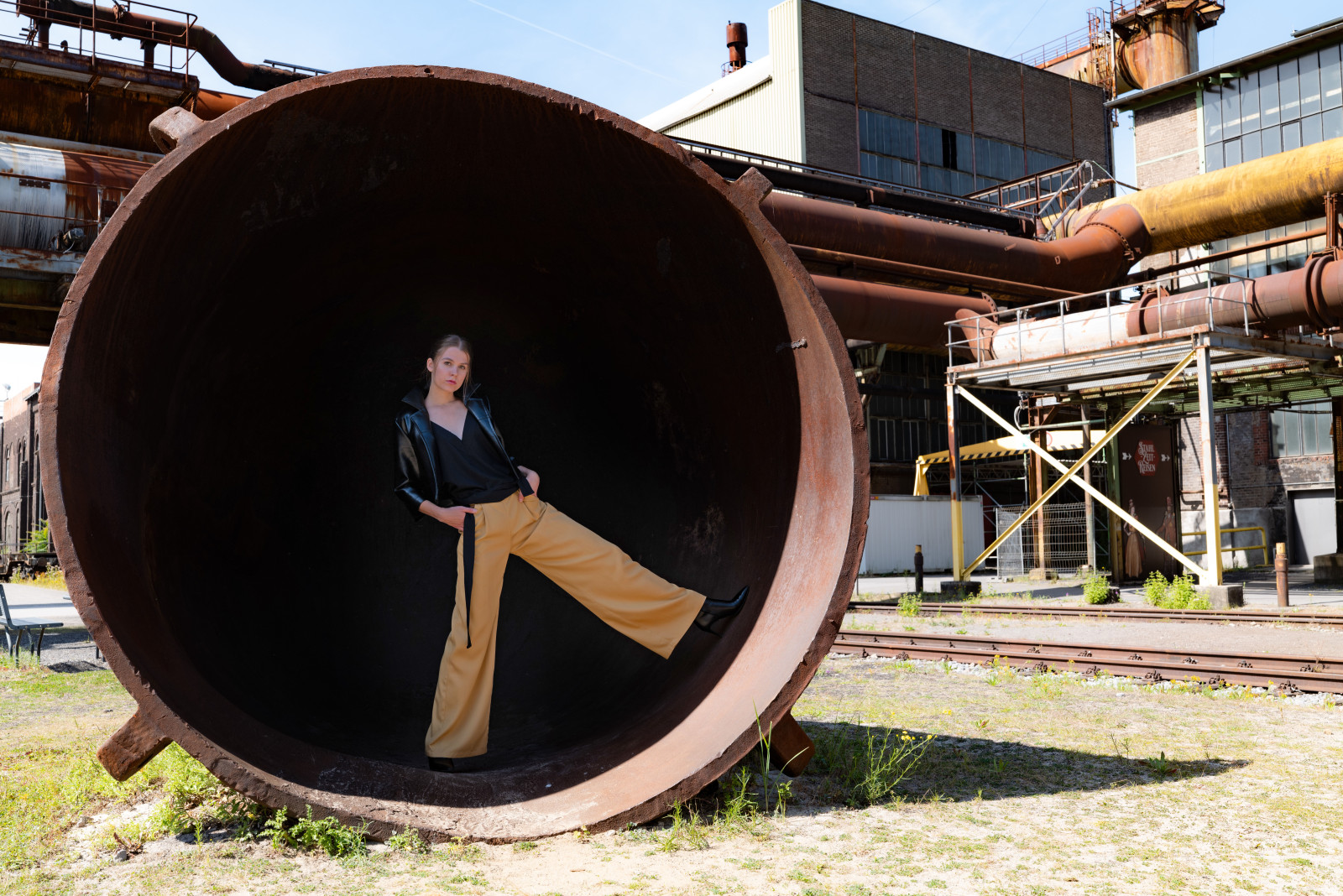 Hannah zeigt eine Hose in Rewoven Twill, im Farbton Golden Sand, das Top dazu ist aus recyceltem Polyester.